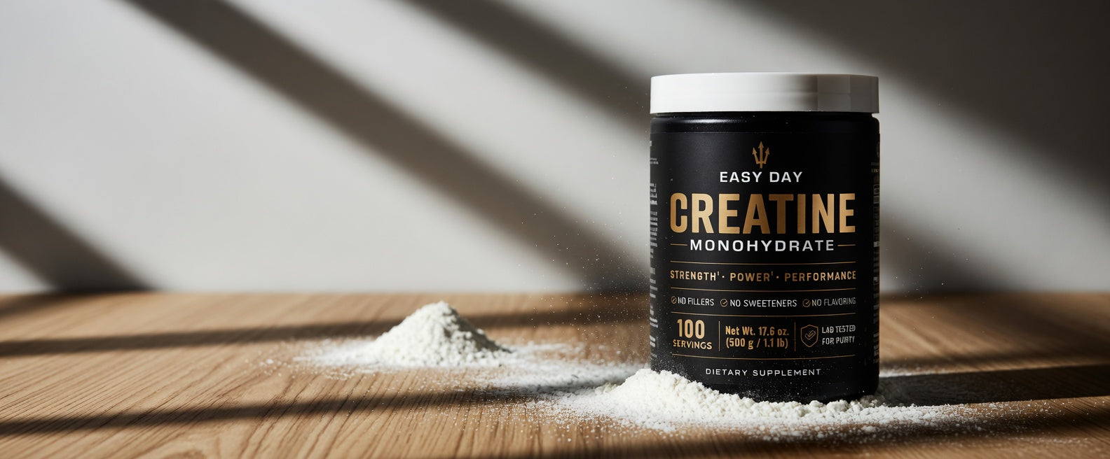 Black supplement container labeled 'Creatine Monohydrate' on a wooden surface with a white background